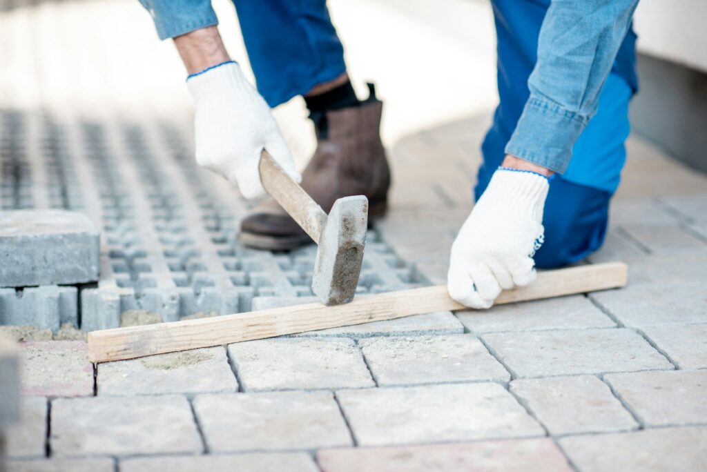 Builder laying paving tiles